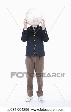 Stock Photograph - a male student with school uniform covering his face with a globe. Fotosearch