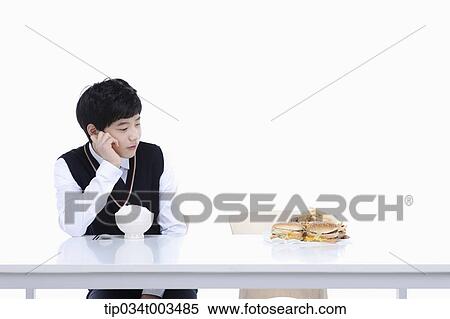 a male student with school uniform staring at burgers while sitting in front of rice bowl View Large Photo Image Stock Photography - a male student with school uniform staring at burgers while sitting in front of rice bowl. Fotosearch