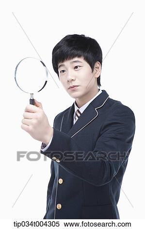 a male student with school uniform looking through a magnifying glass View Large Photo Image Stock Photography - a male student with school uniform looking through a magnifying glass. Fotosearch