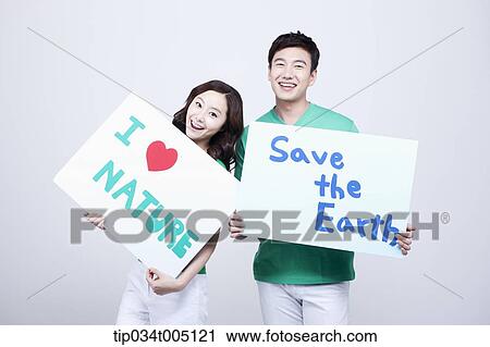 Stock Image - a man and a woman holding signboards with environmentally friendly phrases. Fotosearch