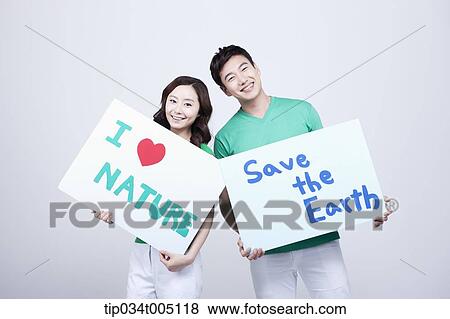 Stock Photo - a man and a woman holding signboards with environmentally friendly phrases. Fotosearch