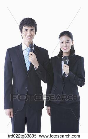 a man and a woman in black suit standing with microphones View Large Photo Image Stock Photography - a man and a woman in black suit standing with microphones . Fotosearch