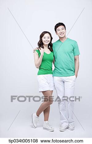 a man and a woman in green t-shirt posing with arms around each other View Large Photo Image Stock Photo - a man and a woman in green t-shirt posing with arms around each other. Fotosearch