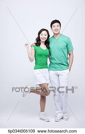 a man and a woman in green t-shirt posing with arms around each other View Large Photo Image Stock Photo - a man and a woman in green t-shirt posing with arms around each other. Fotosearch
