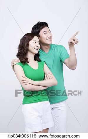 a man and a woman in green t-shirt smiling while looking at same place View Large Photo Image Stock Photograph - a man and a woman in green t-shirt smiling while looking at same place. Fotosearch