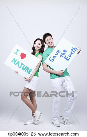 Stock Photography - a man and a woman posing holding signboards with environmentally friendly phrases. Fotosearch