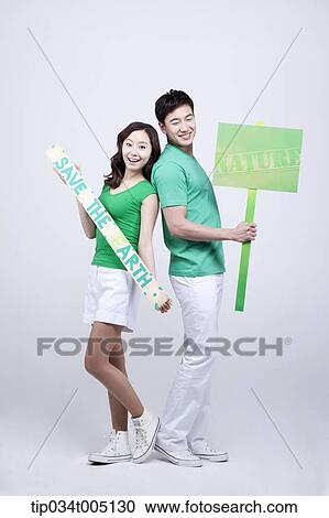 a man and a woman posing with signboards saying environmentally friendly phrases View Large Photo Image Stock Image - a man and a woman posing with signboards saying environmentally friendly phrases. Fotosearch
