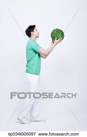 a man in green t-shirt catching a ball made from grass View Large Photo Image Stock Photo - a man in green t-shirt catching a ball made from grass . Fotosearch