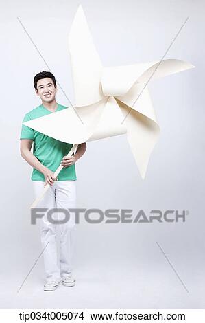 a man in green t-shirt holding a giant pinwheel View Large Photo Image Picture - a man in green t-shirt holding a giant pinwheel. Fotosearch