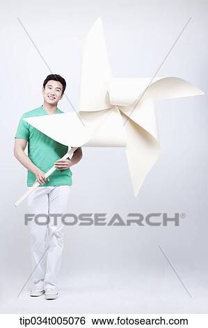 a man in green t-shirt holding a giant pinwheel View Large Photo Image Stock Photograph - a man in green t-shirt holding a giant pinwheel. Fotosearch