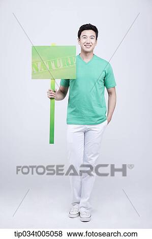 a man in green t-shirt holding a picket with nature sign View Large Photo Image Stock Photo - a man in green t-shirt holding a picket with nature sign . Fotosearch