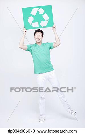 a man in green t-shirt holding a signboard with recycling logo View Large Photo Image Stock Image - a man in green t-shirt holding a signboard with recycling logo. Fotosearch