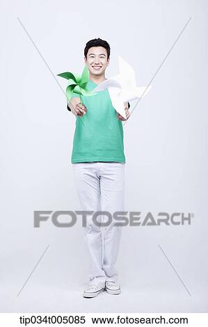a man in green t-shirt holding two pinwheels View Large Photo Image Stock Photography - a man in green t-shirt holding two pinwheels. Fotosearch