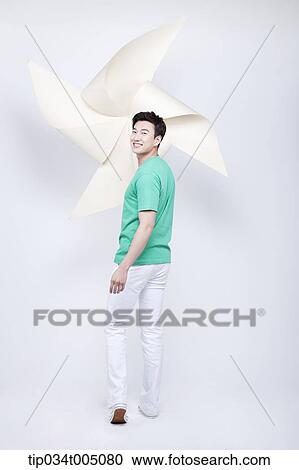 a man in green t-shirt turning back with a giant pinwheel in his hand View Large Photo Image Stock Image - a man in green t-shirt turning back with a giant pinwheel in his hand. Fotosearch