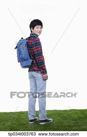 Stock Image - a man looking behind wearing a backpack. Fotosearch