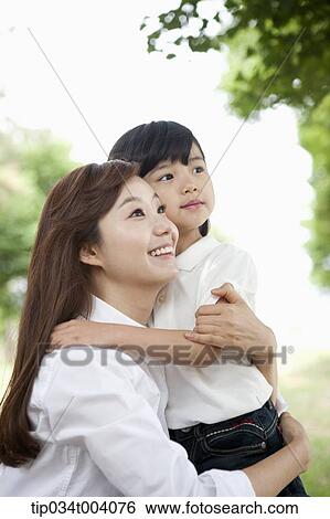 Stock Photograph - a mother and daughter hugging each other. Fotosearch