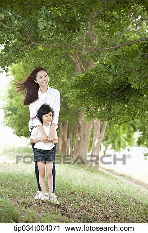 a mother standing behind her son View Large Photo Image Stock Image - a mother standing behind her son . Fotosearch
