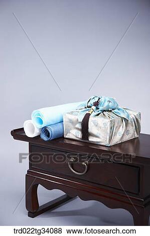 Stock Photo - a package in Korean traditional wrap and Korean traditional paper rolls on a table. Fotosearch