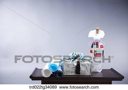 a package in Korean traditional wrap between Korean traditional paper rolls and a bottle cover View Large Photo Image Stock Photo - a package in Korean traditional wrap between Korean traditional paper rolls and a bottle cover. Fotosearch