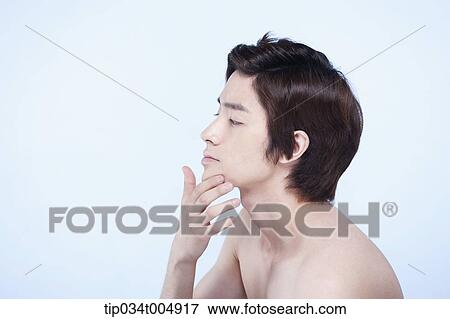 Stock Photo - a side shot of a topless man touching his chin. Fotosearch
