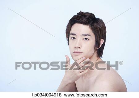 Stock Photo - a side shot of a topless man touching his chin. Fotosearch