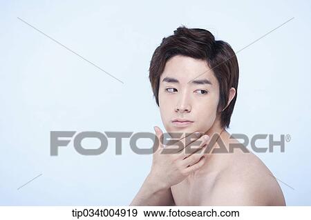 Stock Photo - a side shot of a topless man touching his chin. Fotosearch