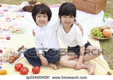 Stock Photo - a son and a daughter on a picnic blanket. Fotosearch