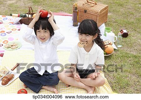 a son holding a tomato on his head with a sister next to him View Large Photo Image Stock Photograph - a son holding a tomato on his head with a sister next to him . Fotosearch