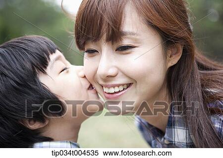 Stock Photography - a son kissing on mother's cheek. Fotosearch