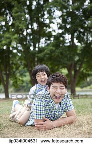 Stock Image - a son on dad's back . Fotosearch