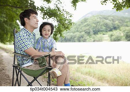 a son sitting on dad's lap View Large Photo Image Stock Image - a son sitting on dad's lap. Fotosearch