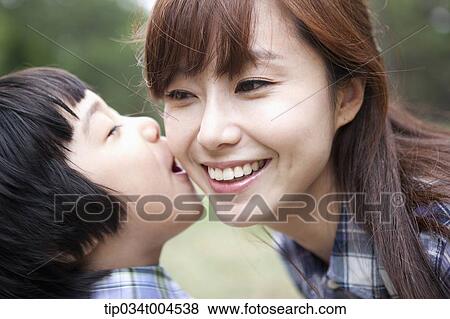 Stock Photo - a son trying to kiss mother. Fotosearch