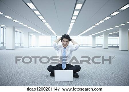 a stressed businessman using laptop on the floor of an empty room View Large Photo Image Stock Photo - a stressed businessman using laptop on the floor of an empty room. Fotosearch
