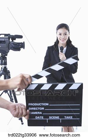 a studio camera and action board in front of woman in a black suit with a microphone View Large Photo Image Stock Photograph - a studio camera and action board in front of woman in a black suit with a microphone . Fotosearch