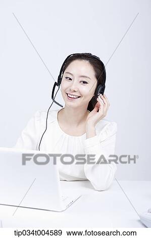 a telemarketer smiling touching her headset View Large Photo Image Stock Photo - a telemarketer smiling touching her headset. Fotosearch