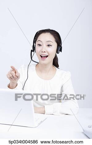 Stock Photograph - a telemarketer talking while pointing. Fotosearch