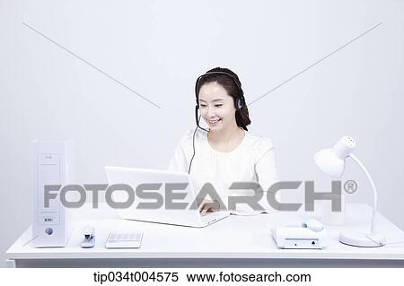 Stock Photography - a telemarketer working at a white office desk. Fotosearch