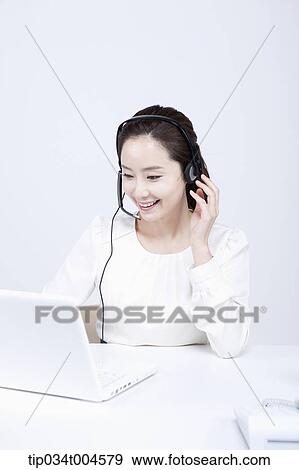 a telemarketer working with a white laptop View Large Photo Image Stock Photo - a telemarketer working with a white laptop. Fotosearch