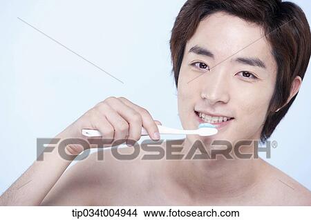 a topless man brushing his teeth View Large Photo Image Picture - a topless man brushing his teeth. Fotosearch