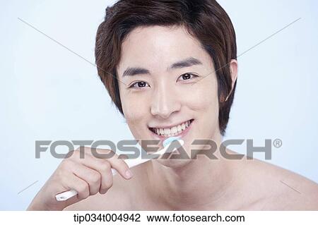 Stock Image - a topless man brushing his teeth. Fotosearch