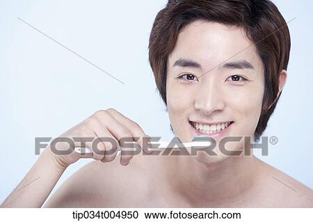 a topless man brushing his teeth View Large Photo Image Stock Image - a topless man brushing his teeth. Fotosearch