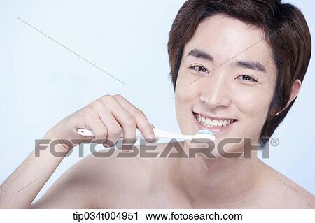 Stock Image - a topless man brushing his teeth. Fotosearch