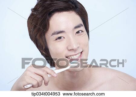 Stock Image - a topless man brushing his teeth. Fotosearch