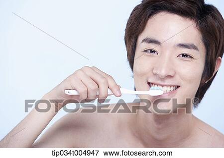 Stock Photo - a topless man brushing his teeth. Fotosearch