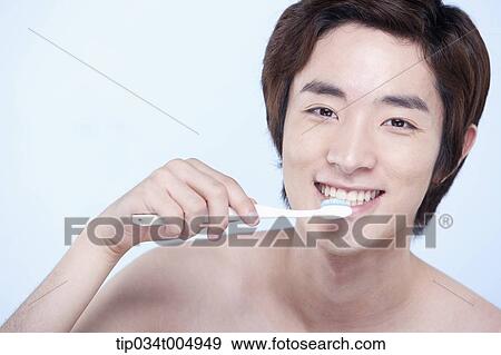 Stock Photo - a topless man brushing his teeth. Fotosearch