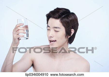 Stock Image - a topless man feeling good after a glass of water. Fotosearch