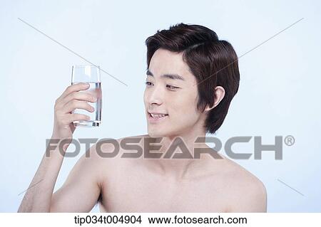 a topless man holding a glass of water View Large Photo Image Picture - a topless man holding a glass of water. Fotosearch