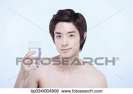 Stock Image - a topless man holding a glass of water. Fotosearch