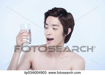 Stock Image - a topless man holding a glass of water. Fotosearch