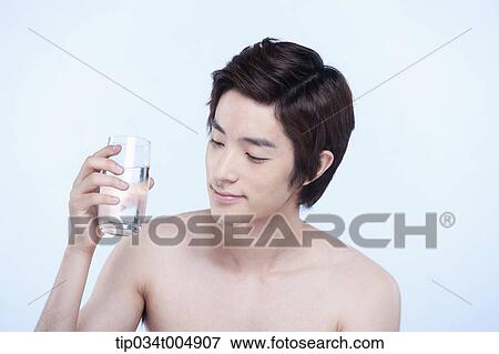Stock Photo - a topless man holding a glass of water. Fotosearch
